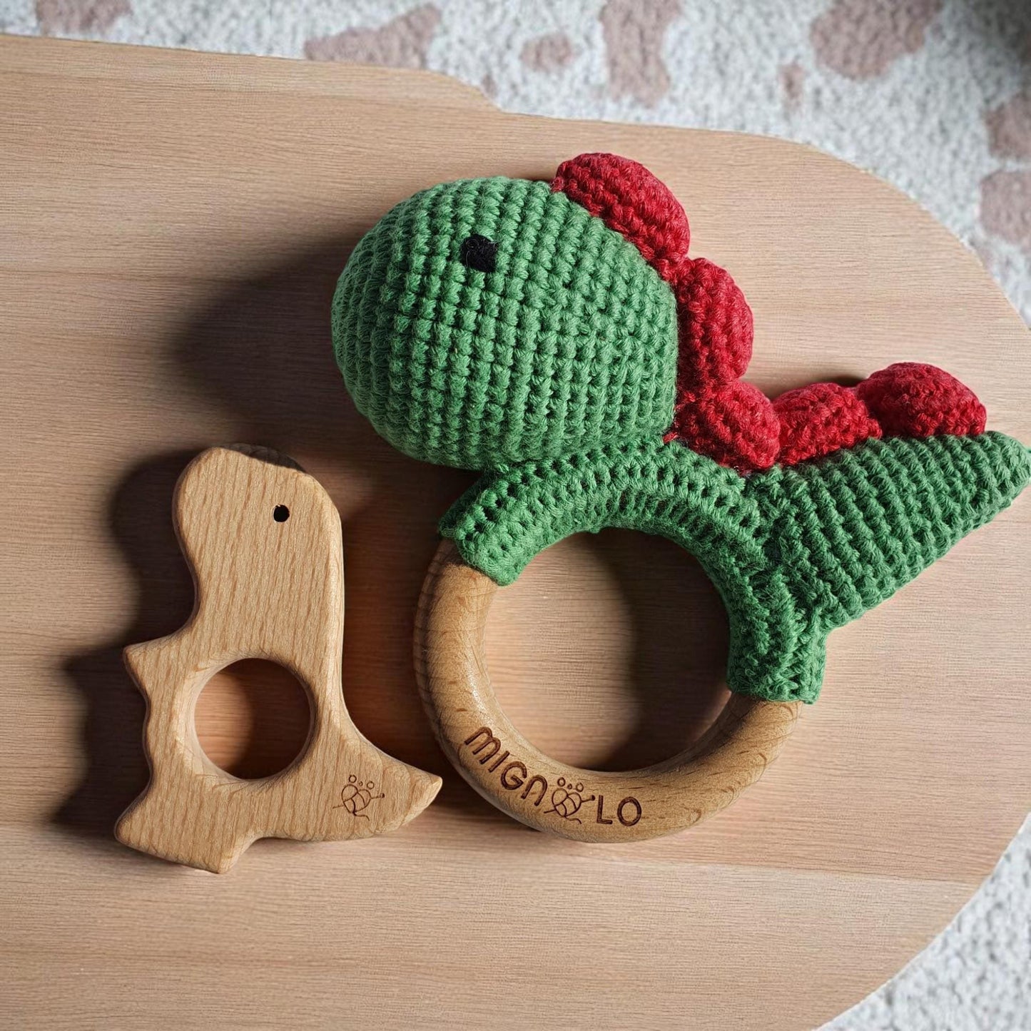 Soft crochet dinosaur baby toy showing texture and wooden element