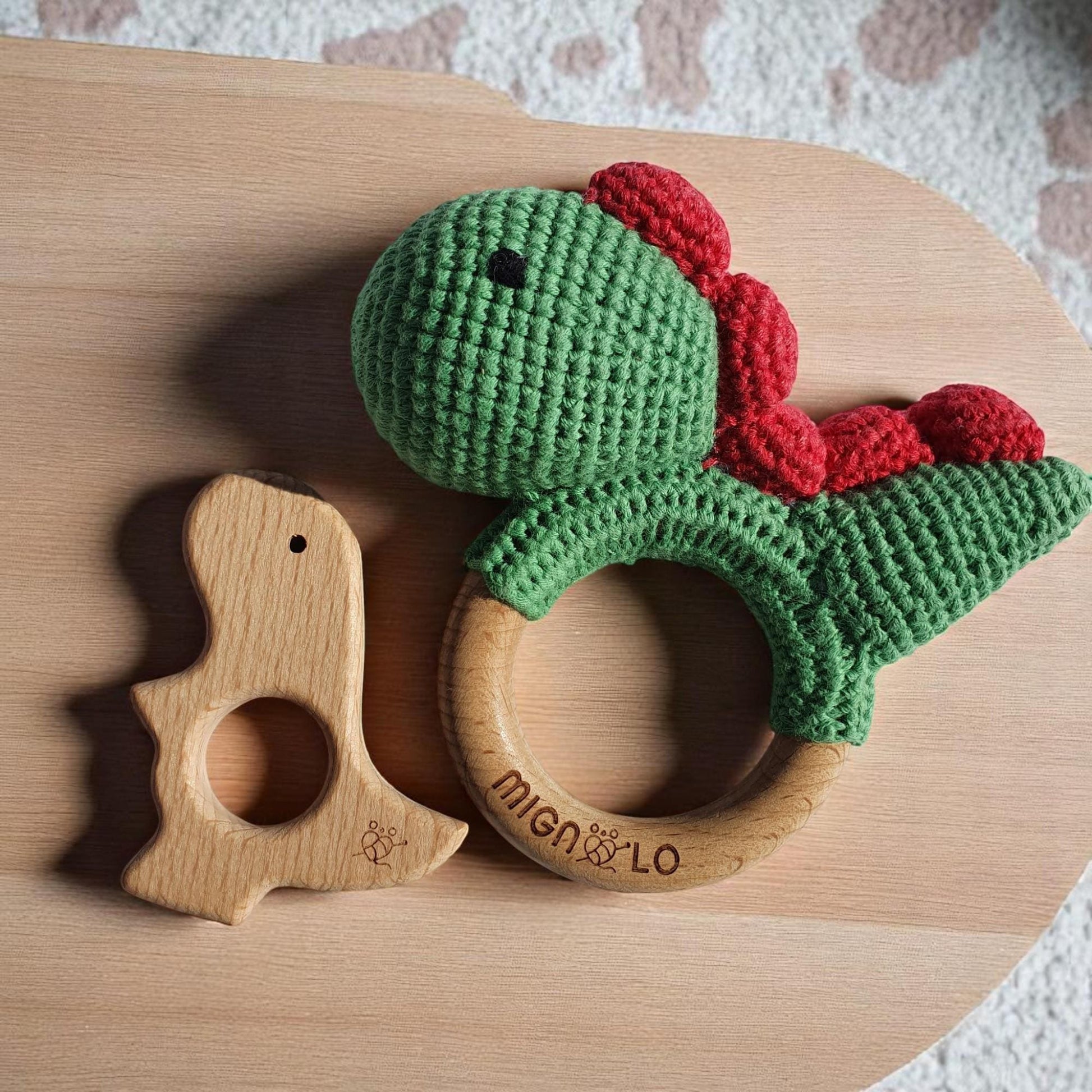 Soft crochet dinosaur baby toy showing texture and wooden element