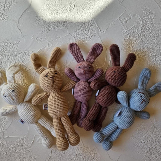 Handmade crochet bunny amigurumi baby comforter in soft colors.