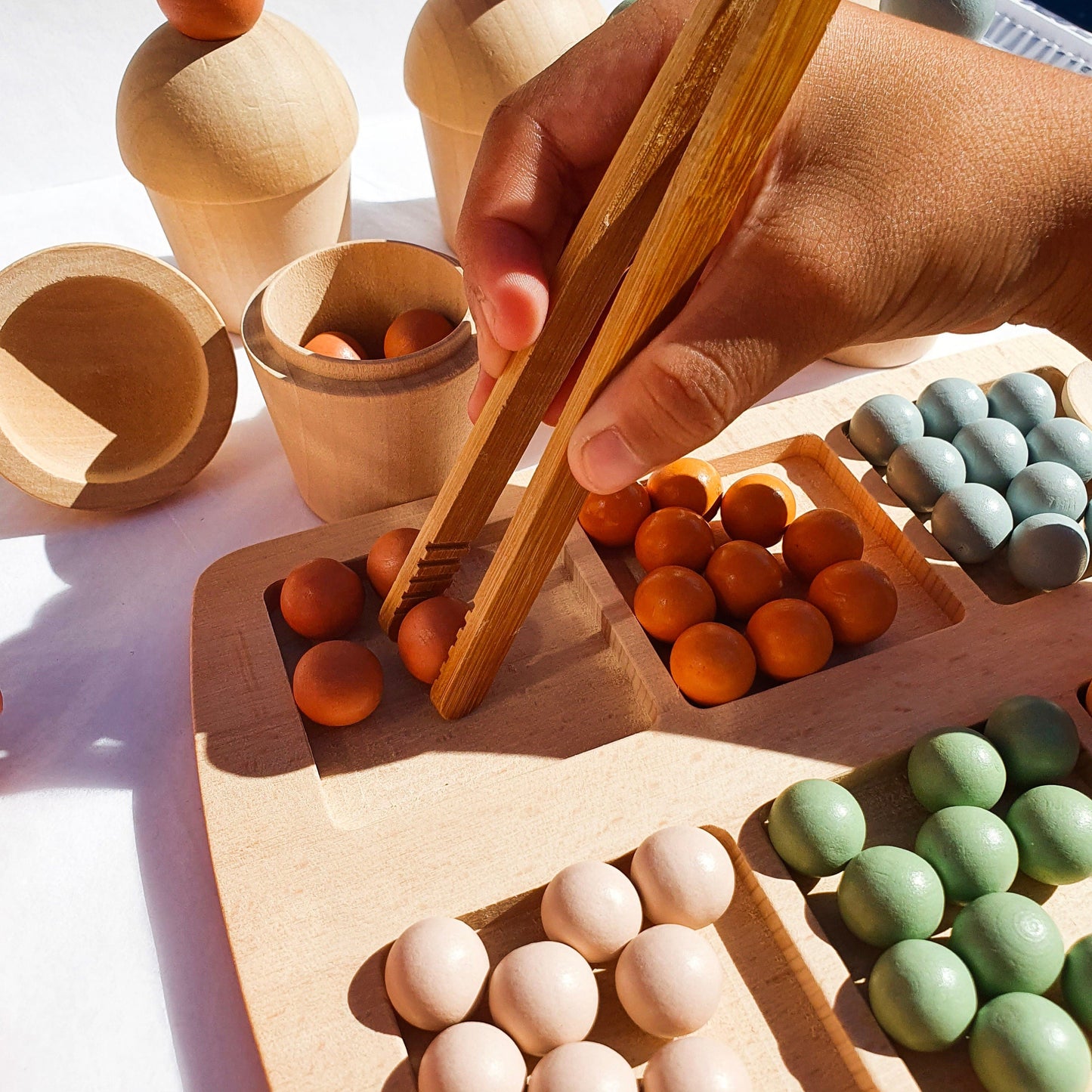 Close-up of wooden marble sorting set with tools and colored marbles